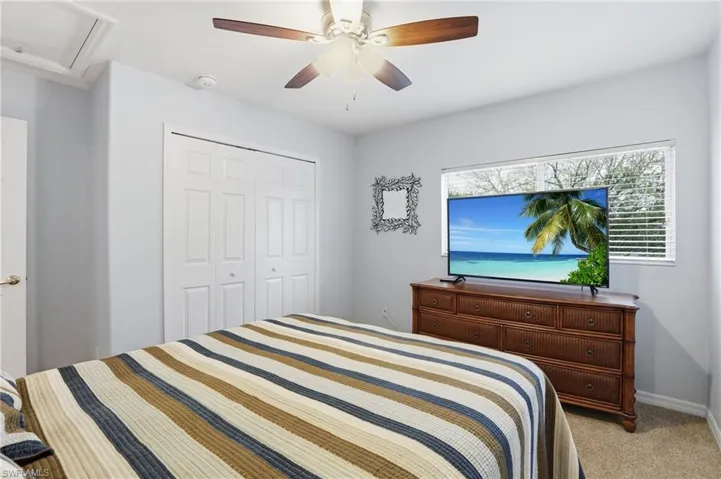 Bedroom featuring light carpet, a closet, and a ceiling fan