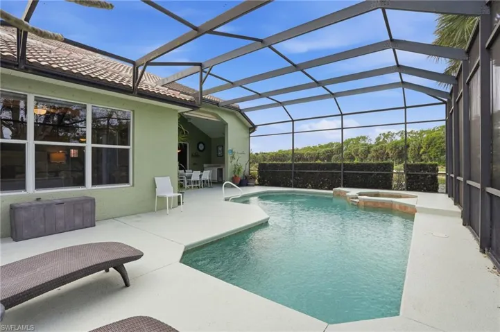 Integrated pool / spa featuring a sunroom, a lanai, and a patio