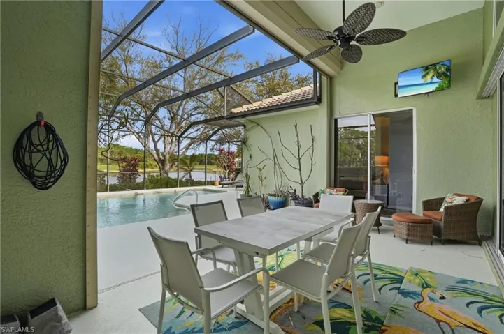 View of patio / terrace featuring a sunroom, an outdoor pool, a lanai, ceiling fan, and outdoor dining space