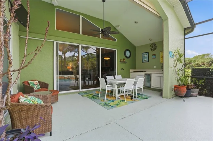 View of patio / terrace with an outdoor kitchen / dining area, a lanai, wine cooler, ceiling fan, and a sunroom