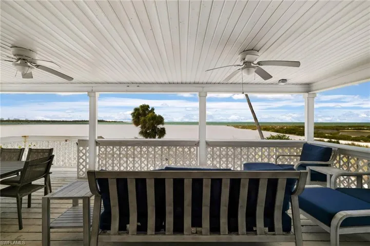 Expansive covered porch with beadboard ceiling and dual ceiling fans - Virtually Edited Image
