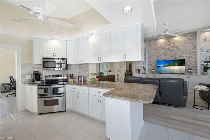 Beautiful kitchen opens to office on the left (pocket door) and Great Room on the right. Note wrap around breakfast bar overlaps at least 6 bar stools!