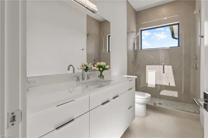 Full bath featuring vanity, a stall shower, and light tile patterned floors