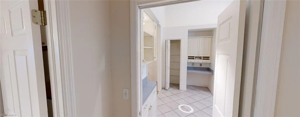 Hallway featuring light tile patterned flooring