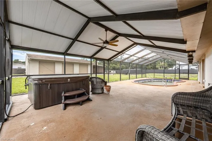 Sunroom with a hot tub, a patio, lofted ceiling, and a ceiling fan