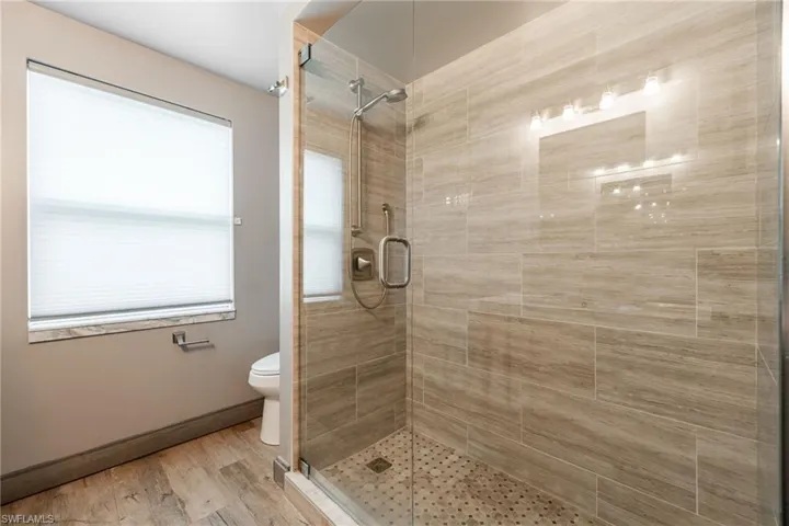 Full bathroom with a stall shower and light wood finished floors