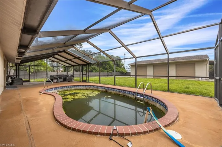 Outdoor pool featuring a sunroom, a yard, a lanai, a patio area, and a garden pond