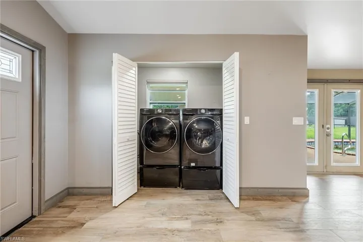 Laundry room featuring light wood-type flooring and washer and clothes dryer