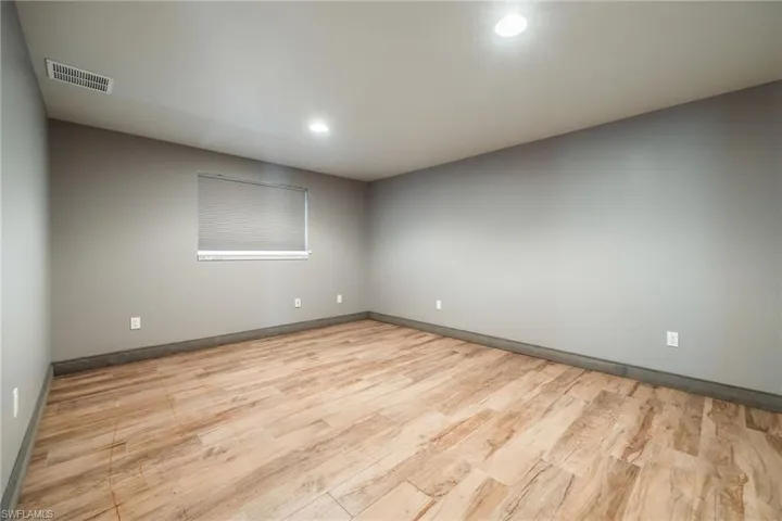 Empty room featuring light wood finished floors and recessed lighting