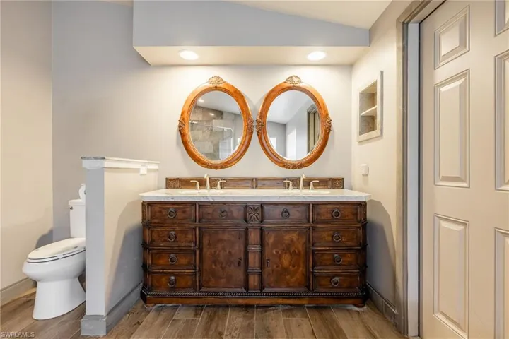 Bathroom with double vanity and wood finished floors