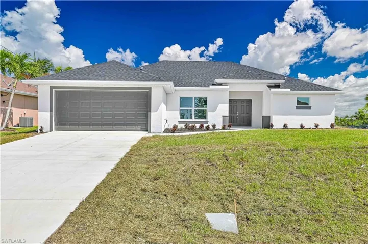 View of front of property featuring a garage, stucco siding, a front lawn, and central AC unit