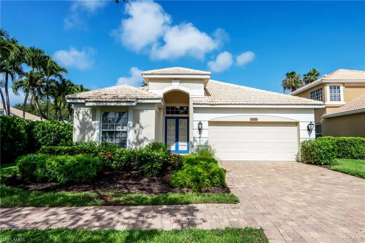 Mediterranean / spanish house with stucco siding, a garage, a tile roof, and driveway
