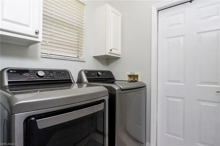 Washroom with washing machine and clothes dryer and cabinet space