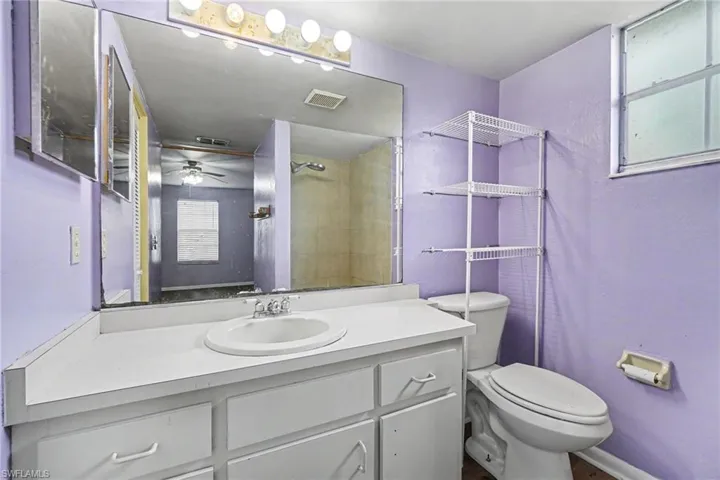 Single vanity with an integrated sink, white countertop, and under-sink cabinetry