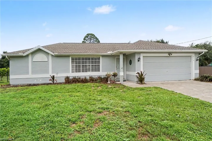 Ranch-style residence featuring a light gray exterior with white trim, a brown shingle roof, and an attached two-car garage