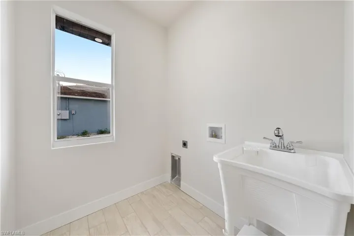 Laundry area featuring light wood-style flooring, hookup for a washing machine, and hookup for an electric dryer