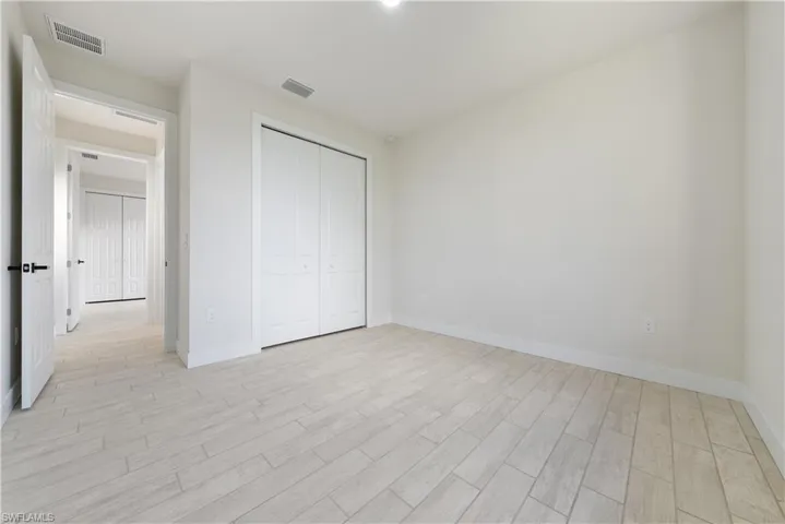 Unfurnished bedroom with light wood finished floors and a closet
