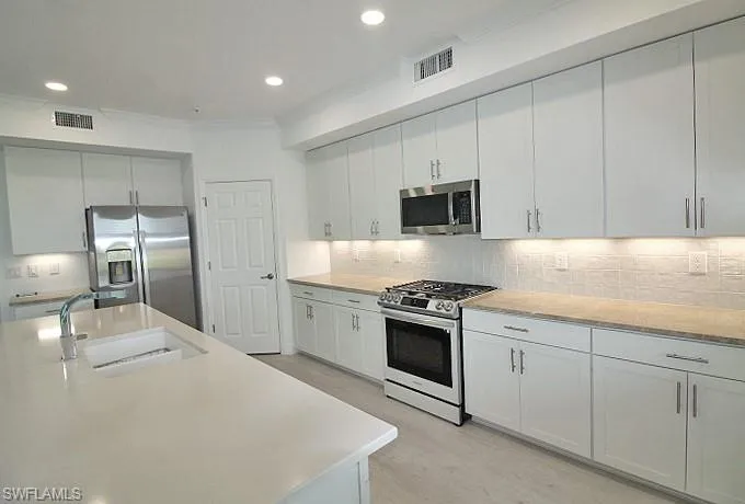 Spacious chef's kitchen! Complimenting counters and tile back splash.