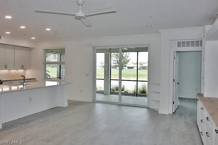 Light gray laminate flooring throughout. Sliding doors to screened in Lanai.