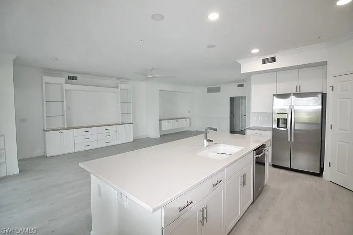 Recessed lighting, SS appliances and beautiful white cabinets.
