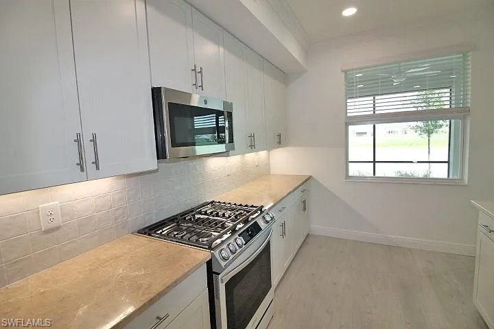 White cabinets, tile back splash and custom granite countertops.