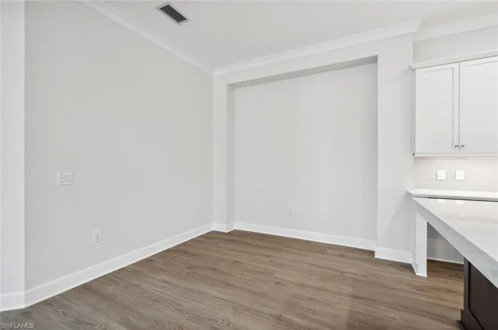 Unfurnished dining area featuring ornamental molding and hardwood / wood-style flooring