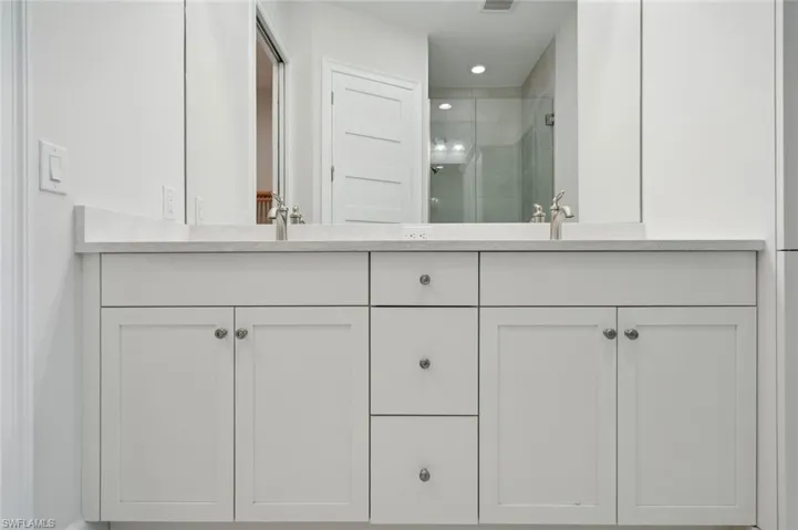 Bathroom featuring walk in shower and double vanity