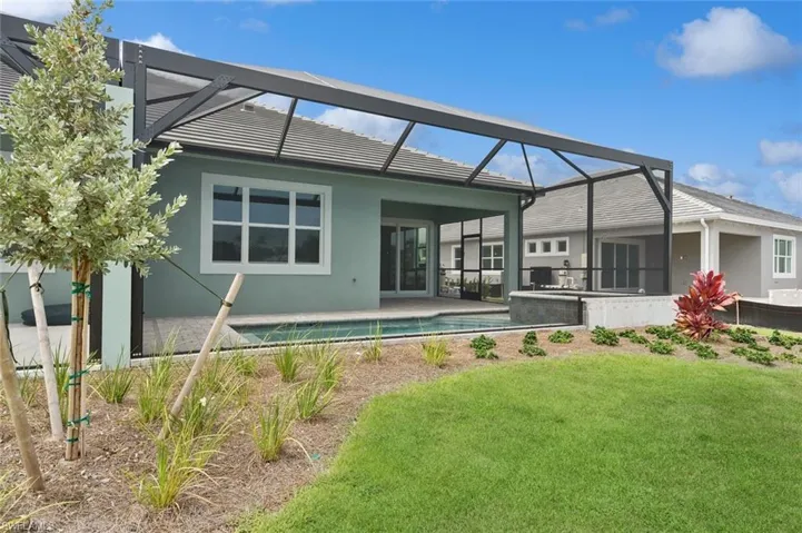 Back of property with a lawn and glass enclosure