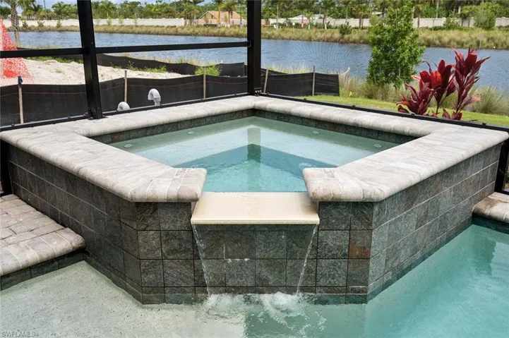 View of swimming pool with an in ground hot tub