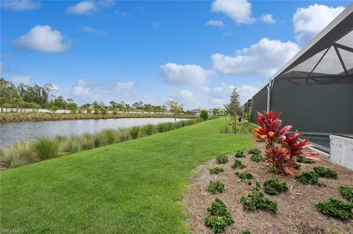 View of yard featuring glass enclosure and a water view