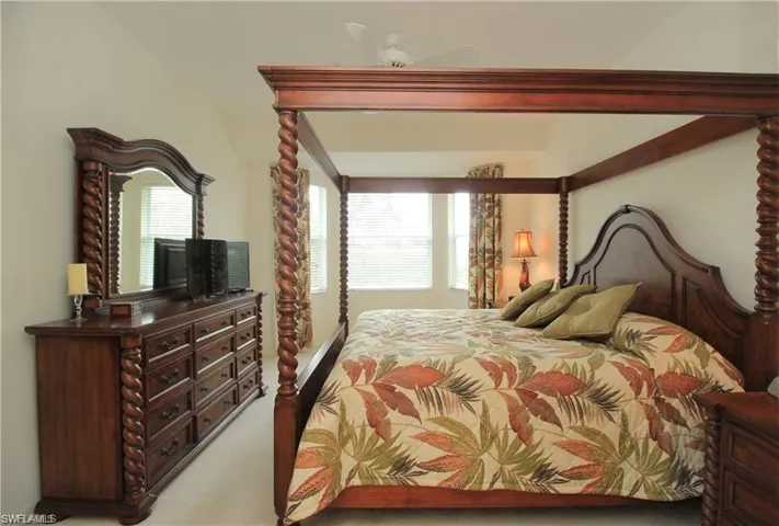 Bedroom with multiple windows, ceiling fan, and carpet