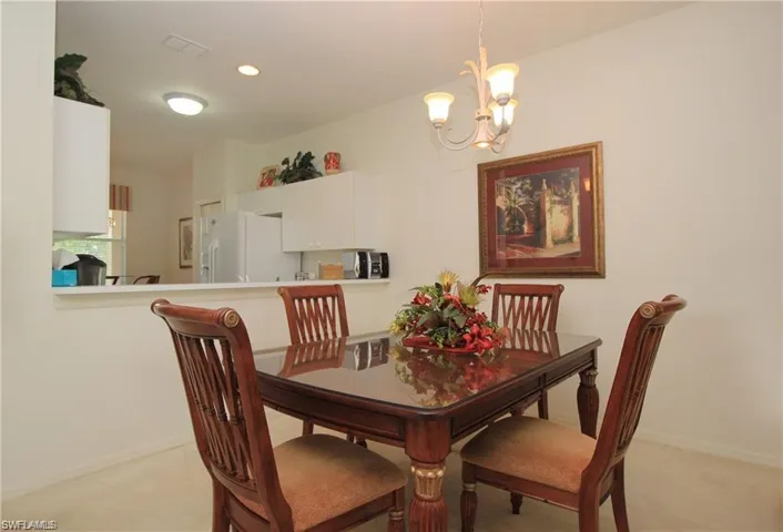Dining area with a notable chandelier and light carpet