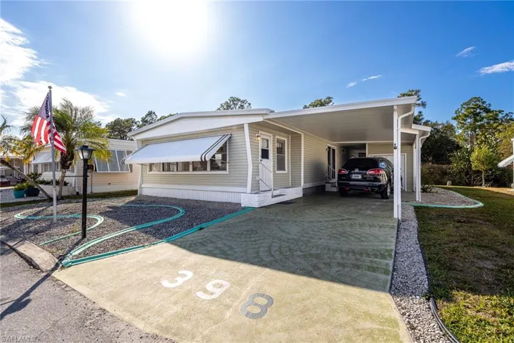View of front facade featuring a carport and concrete driveway