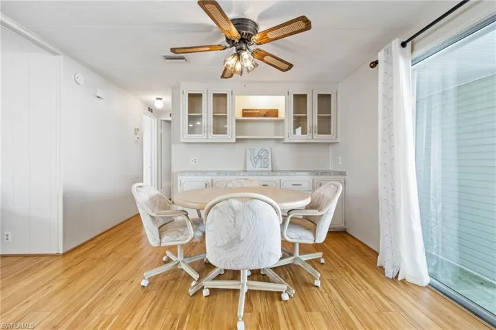 Dining space with a ceiling fan and light wood-type flooring
