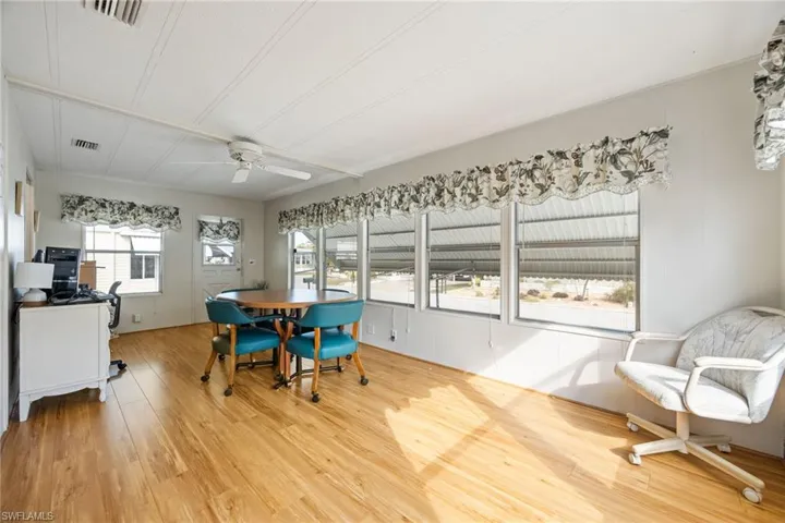 Dining area with light wood-type flooring, ceiling fan, and wood walls