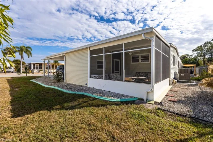 View of side of home featuring a sunroom, a yard, and a carport