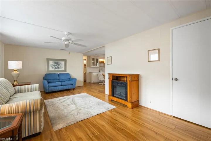Living room with light wood finished floors and ceiling fan