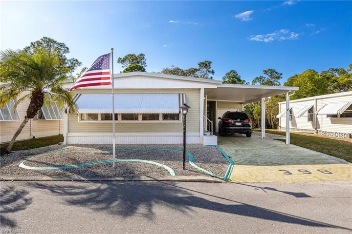 Manufactured / mobile home featuring a carport and driveway