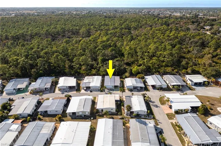 Aerial view of property and surrounding area featuring nearby suburban area