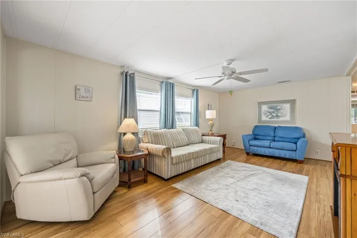 Living area with light wood-type flooring and a ceiling fan