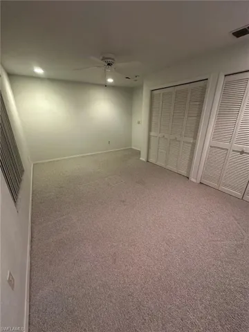 Unfurnished bedroom with multiple closets, carpet floors, and ceiling fan