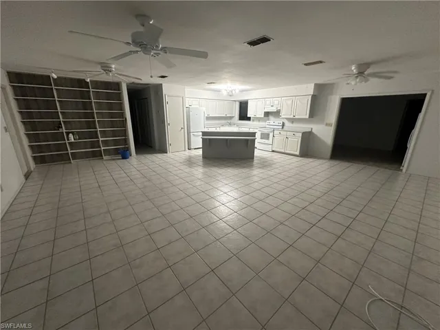 Unfurnished living room featuring light tile patterned flooring and ceiling fan