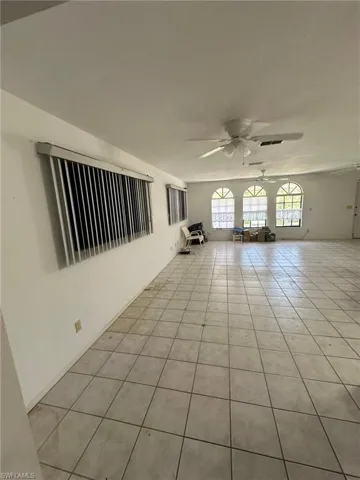 Empty room featuring light tile patterned floors and ceiling fan