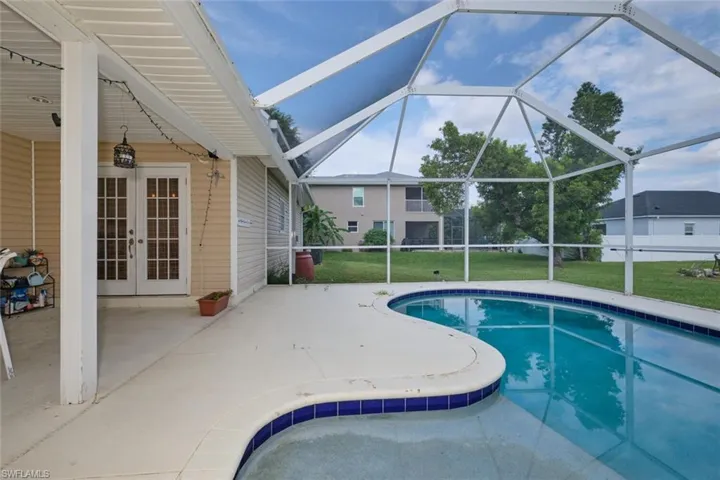 View of pool with a patio, a lawn, a lanai, and french doors