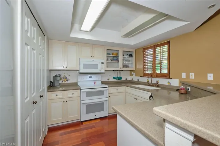 Pantry to the left, appliances include a double oven, dishwasher and refrigerator.  Corian countertops.  Lights can be brought up to 2025 by adding a ceiling fan and/or recessed lighting.  Very workable kitchen!