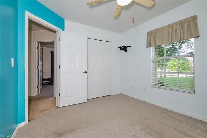 Unfurnished bedroom with light carpet, a closet, and ceiling fan