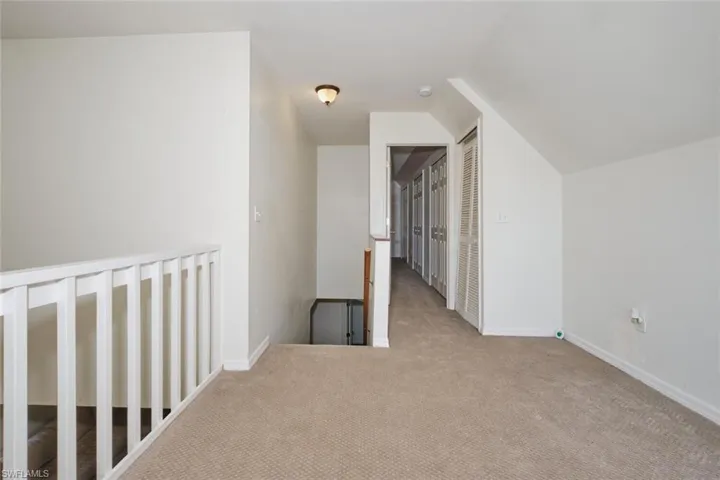 Additional living space with light colored carpet and lofted ceiling