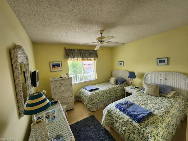 Bedroom featuring carpet flooring, ceiling fan, and a textured ceiling