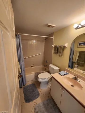Bathroom with vanity, shower / bath combo, and tile patterned floors