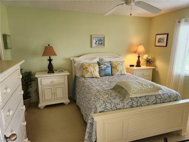 Bedroom featuring carpet flooring, a textured ceiling, and a ceiling fan